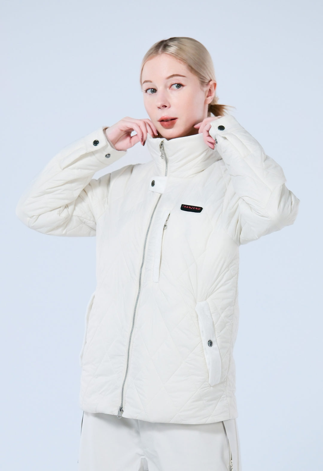 A lady wearing a heated white puffer jacket with mock neck 